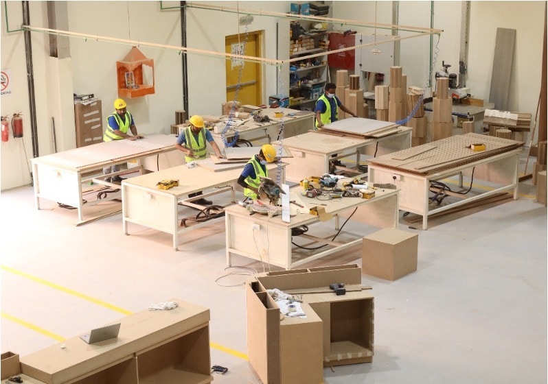 Four craftsmen working at benches in the FOCAL Craft Works facility