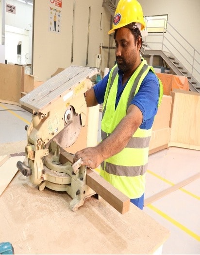 Craftsman operating mitre saw for precision timber cutting